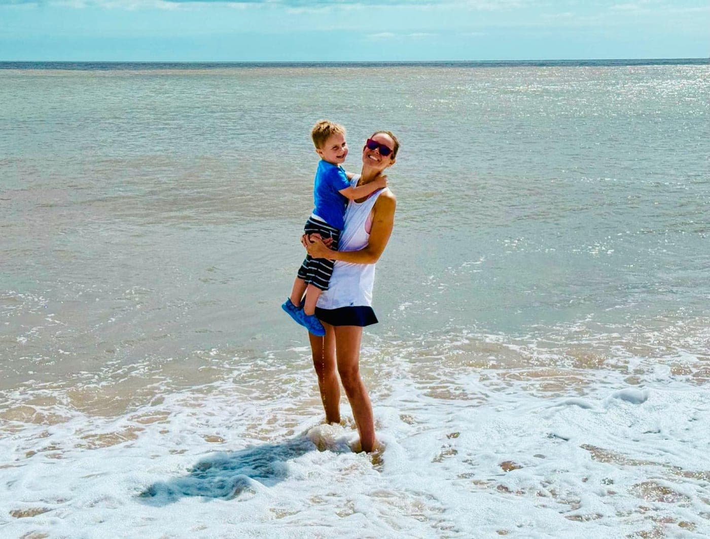 The tappey founders, a mum holding her young son in the surf on a sunny British beach